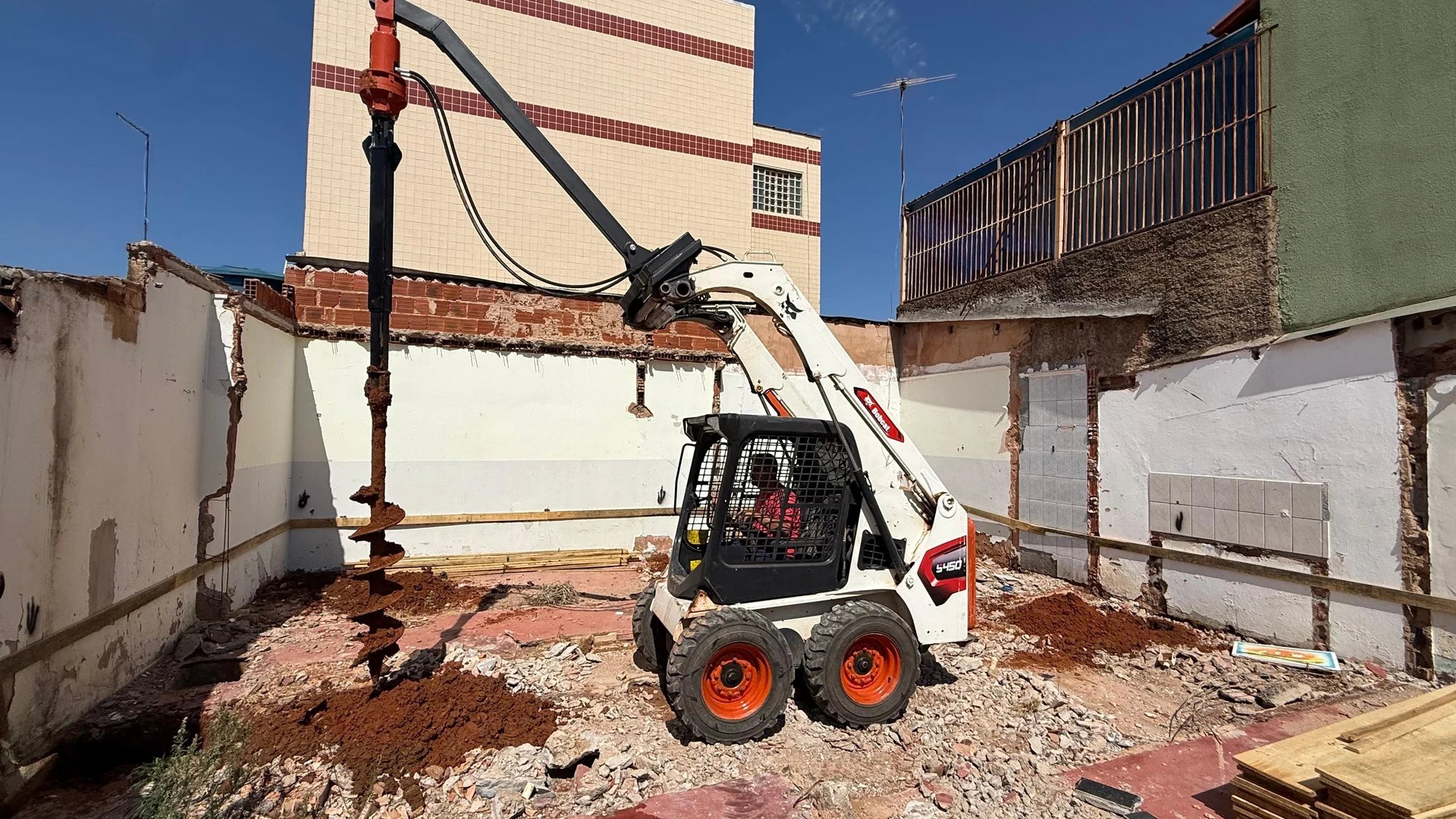 Foto Real da Bobcat S450 com Perfuratriz perfurando estacas de 6m em obra no DF